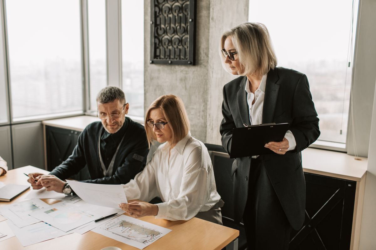Advisers discussing documents with a business client (illustrative stock photo)
