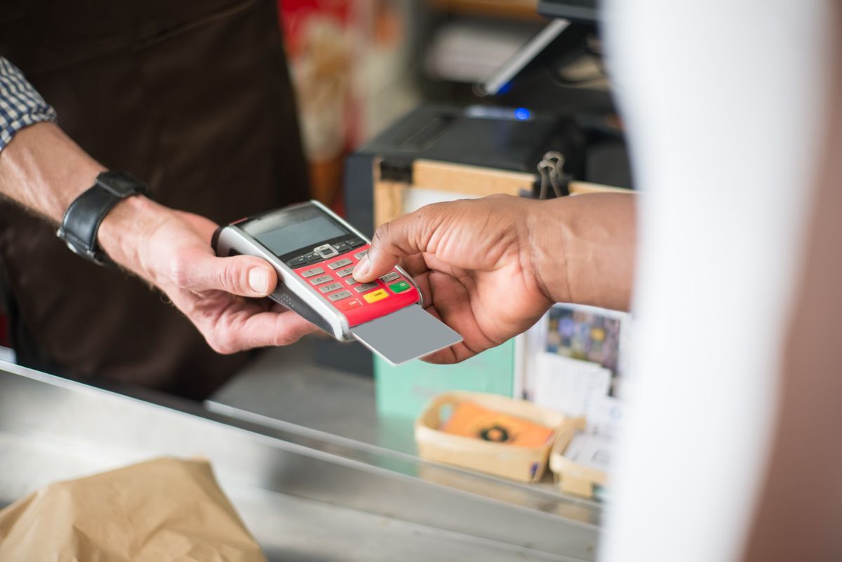 Customer paying by card on a handheld payment terminal (illustrative stock photo)