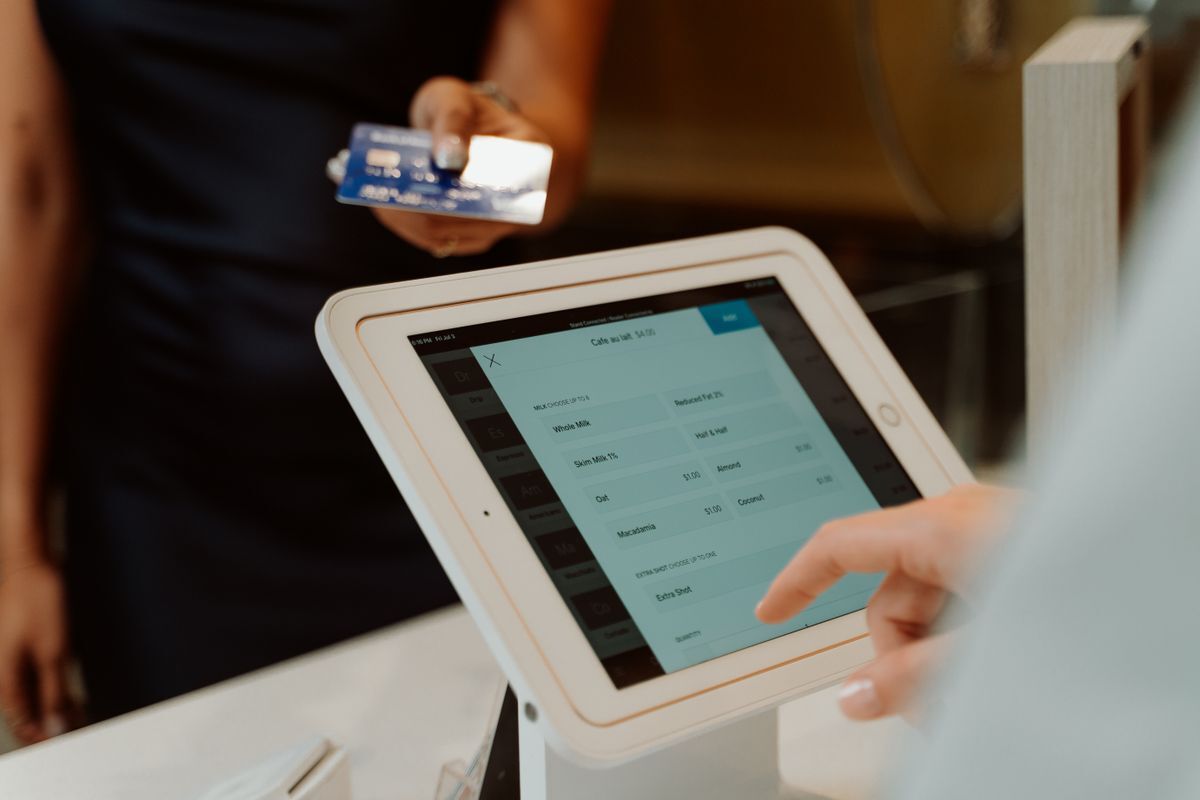 Contactless card payment at a tablet point-of-sale terminal (illustrative stock photo)